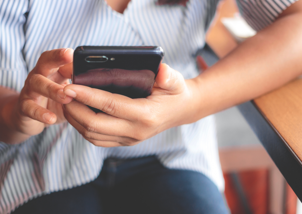 Frau nutzt Smartphone zur Kontaktaufnahme mit Ordnungscoach